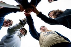 The Trinity College Women's Lacrosse Team in a huddle